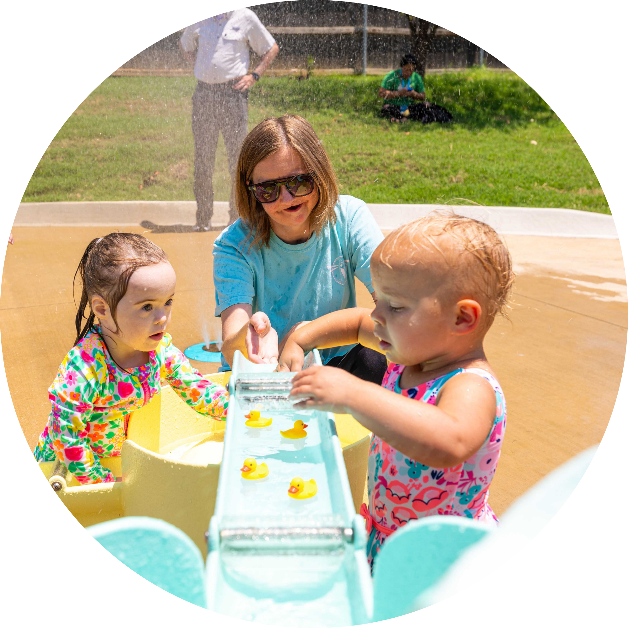 children playing with toy ducks in a water table